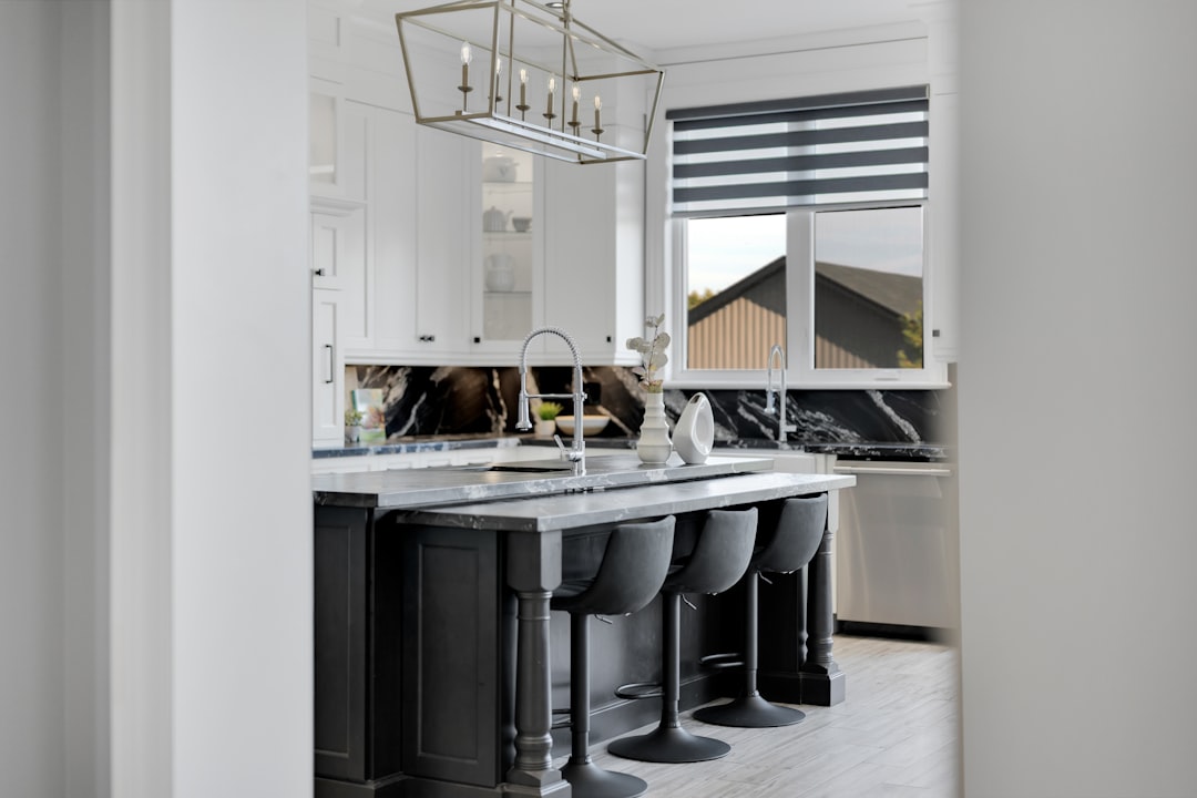 Marble island and bar stools in a luxury kitchen — material selection drives budget variance